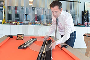 Male billiard player preparing table
