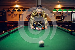 Male billiard player with pyramid places balls