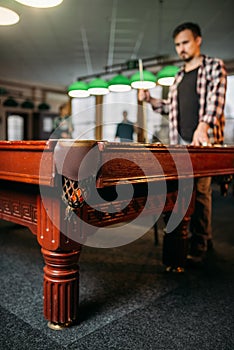 Male billiard player at the table, focus on pocket