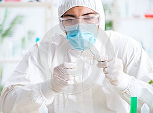 Male biochemist working in the lab on plants