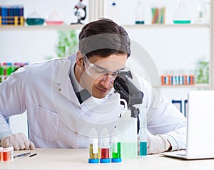 Male biochemist working in the lab on plants