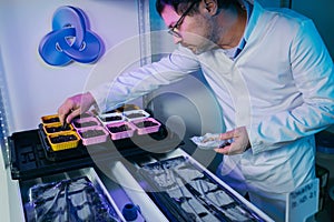 Male biochemist working in the lab on plants