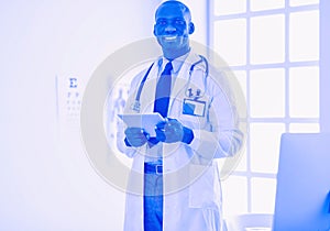 Male black doctor worker with tablet computer standing in hospital