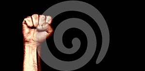 Male black fist on a black background. Aggressiveness, masculinity, the concept of challenge