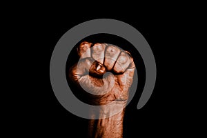 Male black fist on a black background. Aggressiveness, masculinity, the concept of challenge