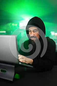 Male black hat hacker hacking security firewall late in the office.Vertical image.