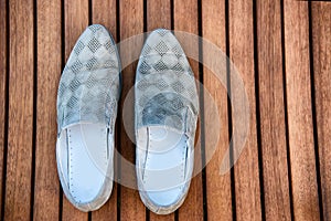 Male blue shoes over the wooden table