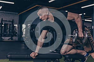 Male bodybuilder lifting dumbbells at the gym