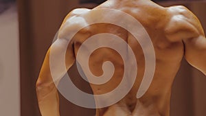 Male bodybuilder showing physique in relaxed side and rear lat spread poses