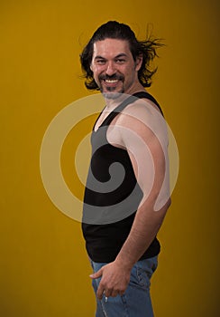 Male bodybuilder wearing dark tanktop on ripped muscular torso in studio shot