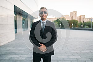 Male bodyguard in suit, earpiece and sunglasses