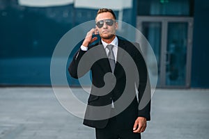 Male bodyguard uses security earpiece outdoors