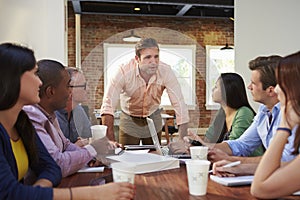 Male Boss Addressing Office Workers At Meeting