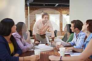 Male Boss Addressing Office Workers At Meeting