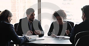 Male boss discuss project with multi ethnic team at meeting