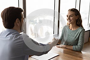 Male boss handshake female applicant at meeting
