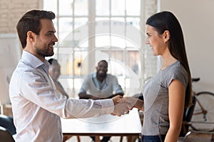 Male boss handshake female employee greeting with promotion