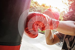 Male boxer boxing in punching bag.