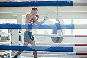 Male boxer fighting at the ring