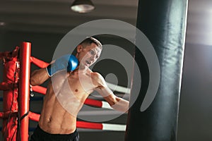 Male boxer hitting punching bag at a boxing studio