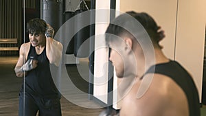 Male boxer shadowboxing in front of mirror