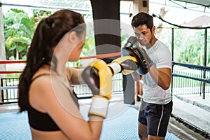 a male boxing coach wearing the pads while training