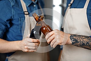 Male brewery worker tasting beer, standing in plant