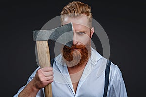 Male brutality. Vintage brutality guy with axe in retro suspenders. Brutal man in suspenders with ax  on black