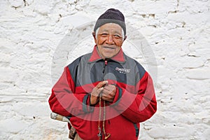 Male Buddhist Pilgrim Clutches Prayer Beads in Temple, Bhutan