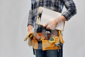 Male builder with clipboard and working tools