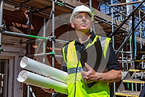 Male Builder Foreman Architect on Building Site With Clipboard and Plans
