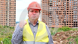 Male builder foreman, worker or architect on construction building site threatening his fist