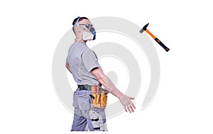 Male Builder, goggles and a respirator, is juggling a hammer, isolated on a white background.