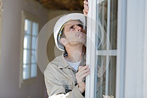 male builder installing window photo