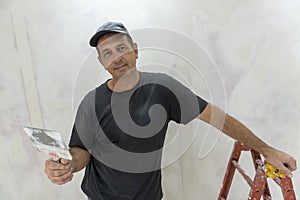 Male builder, master office, plasterer with a tool in working clothes