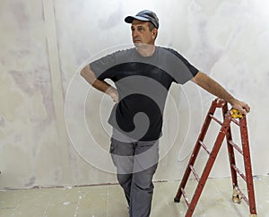 Male builder, master office, plasterer with a tool in working clothes