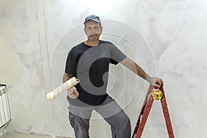 Male builder, master office, plasterer with a tool in working clothes