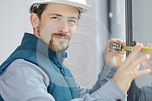 male builder measuring window