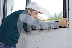 male builder measuring window