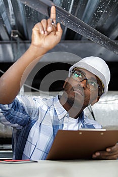 Male builder pointing at ceiling