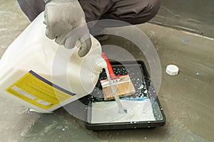 A male builder is priming a wall before further construction work.