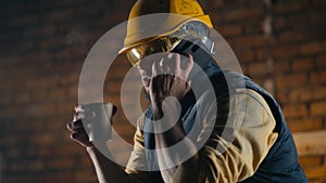 Male builder speaking on smartphone during lunch break