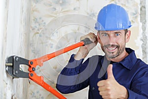Male builder using bolt cropper with thumbs-up photo