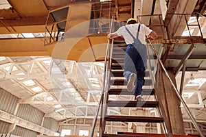 Male builder walking up the stairs at construction site