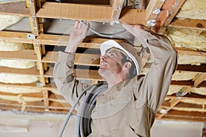 Male builder wiring inside ceiling