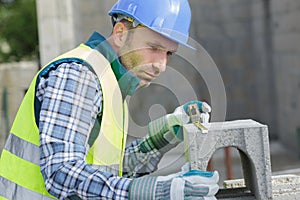 Male builder working with cement block