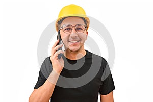 Male builder in a yellow hard hat talking on the phone on a white background. Building, development, teamwork and people