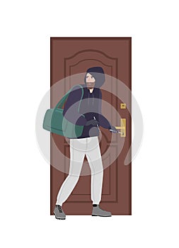 Male burglar wearing hoodie trying to unlock door with lock pick and break in house. Theft, burglary or housebreaking