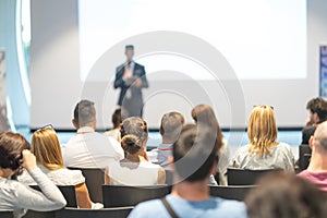 Male business speaker giving a talk at business conference event.