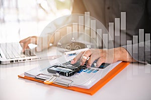 Male businessman calculates financials with graph paper.